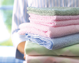 Person with a stack of freshly laundered linens